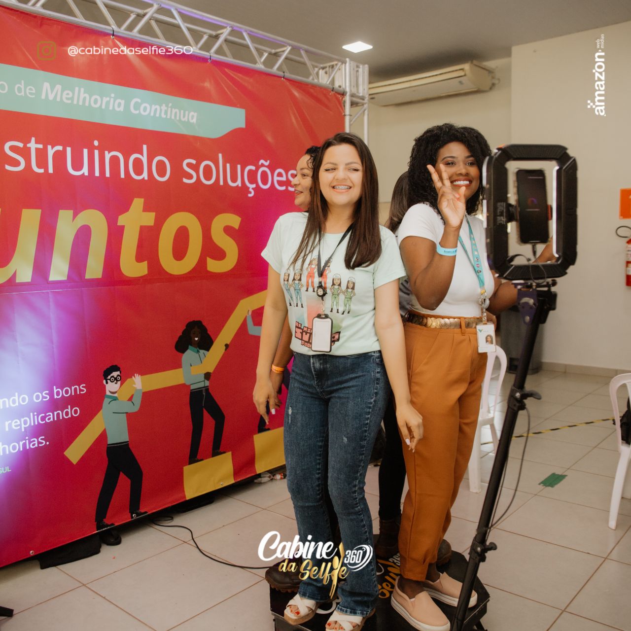 Pessoas se divertindo com o totem fotográfico no evento