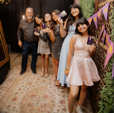 Pessoas sorrindo com o totem fotográfico no evento
